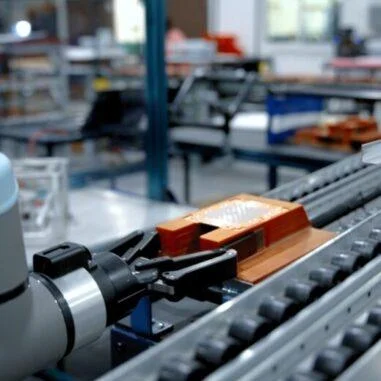 Robotic arm positioning copper coldplate on automated manufacturing line