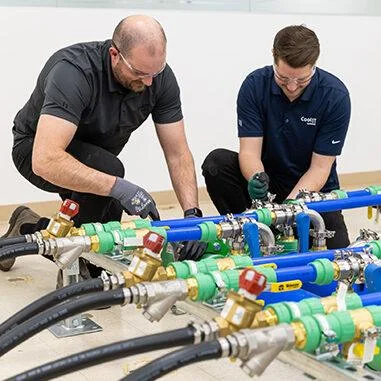 Technicians installing and commissioning data centre liquid cooling piping.