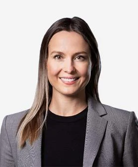A professional headshot of Amy Walsh, smiling and wearing a grey blazer over a black top.