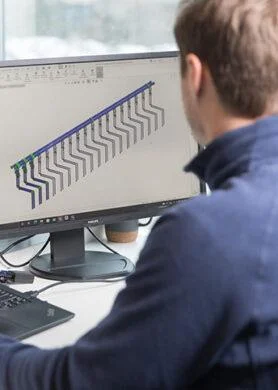 Engineer designing liquid cooling manifold system using CAD software.