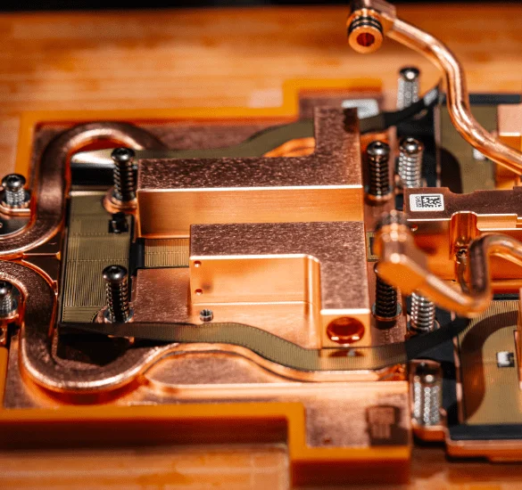An extreme close-up of an intricate copper hardware assembly with multiple springs, screws, and thin internal piping, highlighting high-precision manufacturing.