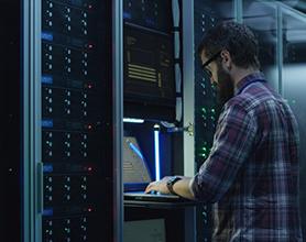 IT technician configuring server rack equipment inside a data center environment