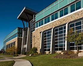 Modern office building exterior with glass façade and landscaped entrance walkway