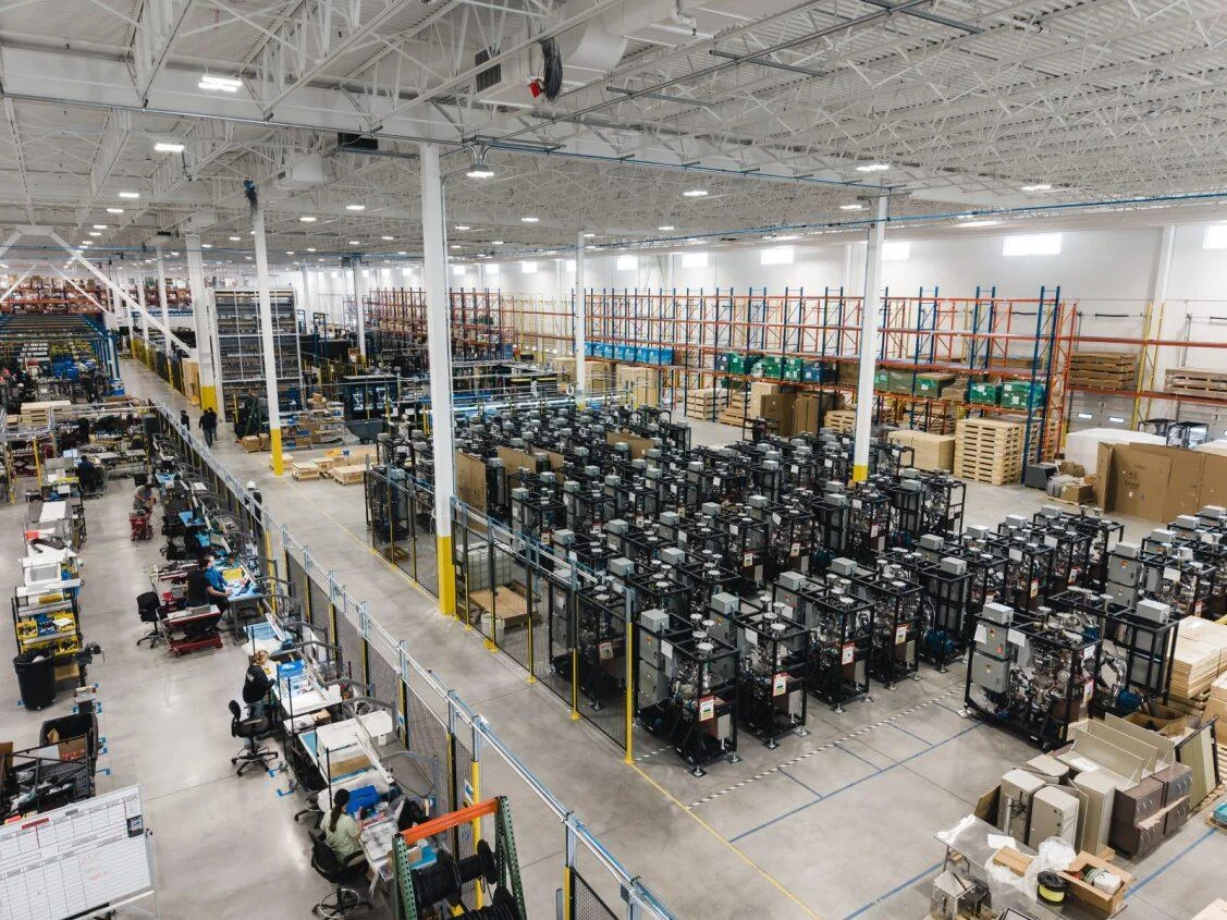 Large-scale manufacturing floor assembling coolant distribution units for data centre liquid cooling.