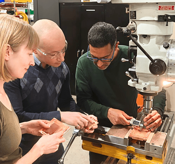 Engineering team inspecting precision-machined coldplate components