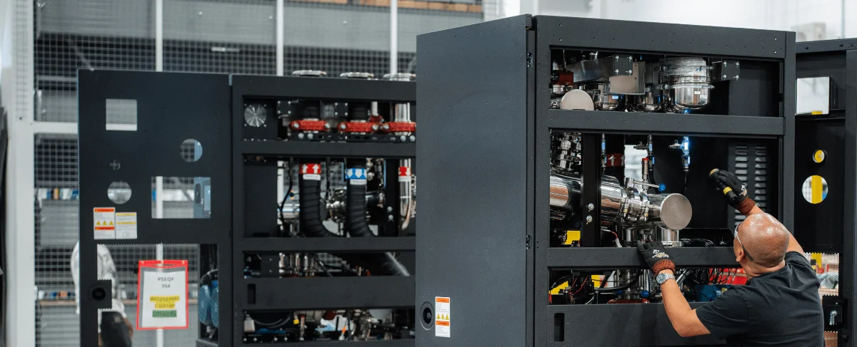 Technician servicing a liquid cooling distribution unit (CDU) inside a data center rack, adjusting internal piping and components.