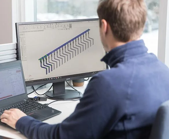 Engineer designing liquid cooling manifold system using CAD software.