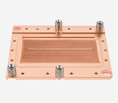 A studio shot of a rectangular copper cooling plate with four corner mounting screws and an intricate internal micro-channel texture visible in the center.