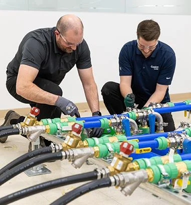 Technicians installing and commissioning data centre liquid cooling piping.