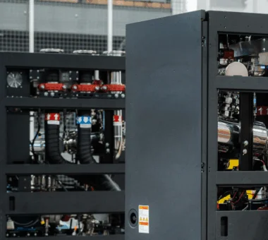 Technician servicing a liquid cooling distribution unit (CDU) inside a data center rack, adjusting internal piping and components.